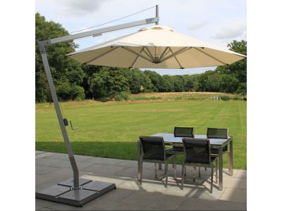 tilting cantilever with white canopy open over a patio table in a garden